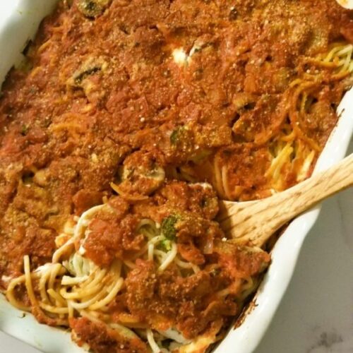 tray of baked spaghetti with tomato sauce, cream cheese and veggies such as broccoli and mushrooms