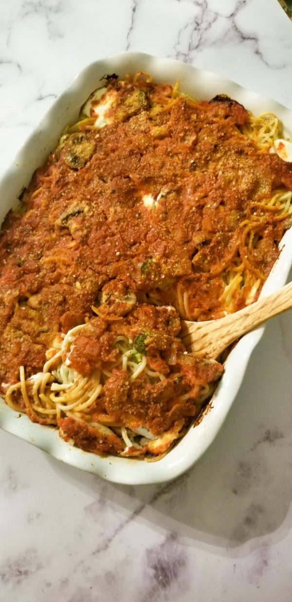 tray of baked spaghetti with tomato sauce, cream cheese and veggies such as broccoli and mushrooms
