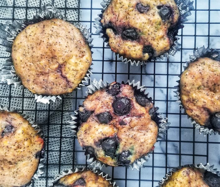 7 blueberry lemon poppy seed muffins on a black wire rack