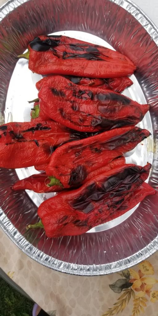 aluminum tray of freshly roasted whole red peppers