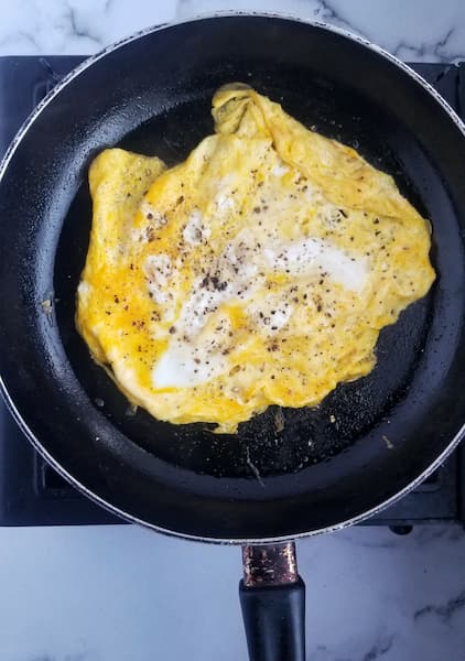 super fluffy and yellow omelette style eggs in a frying pan