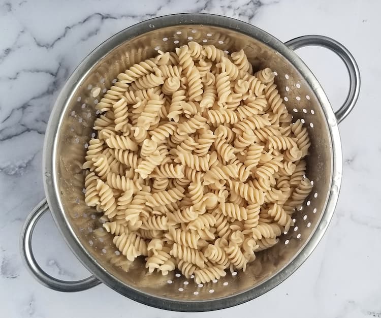 colander of brown rice curly pasta