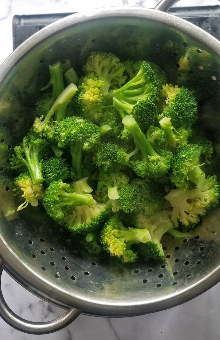 colander of steamed bright green broccoli florets