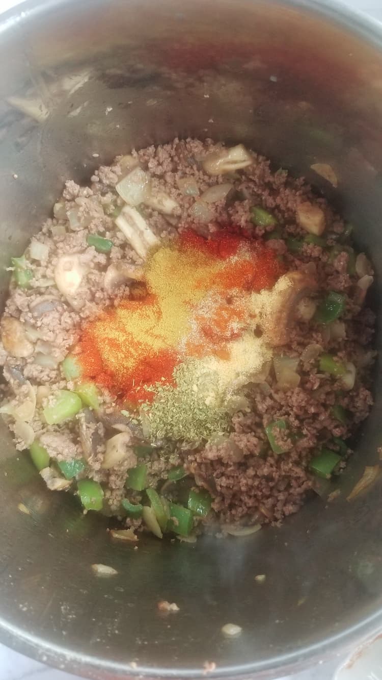 pot with browned ground beef, peppers and spices