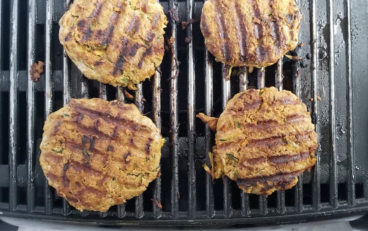 4 zucchini turkey burgers grilling on an indoor grill
