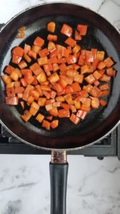 Skillet with diced red peppers in it