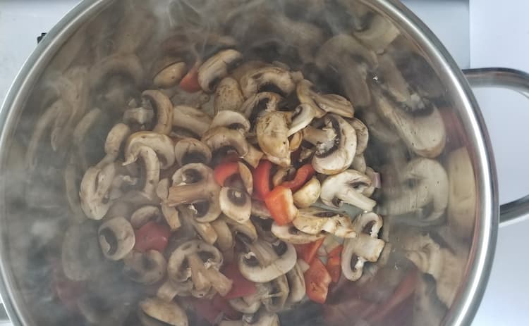 pot of sliced mushrooms and red pepper chunks
