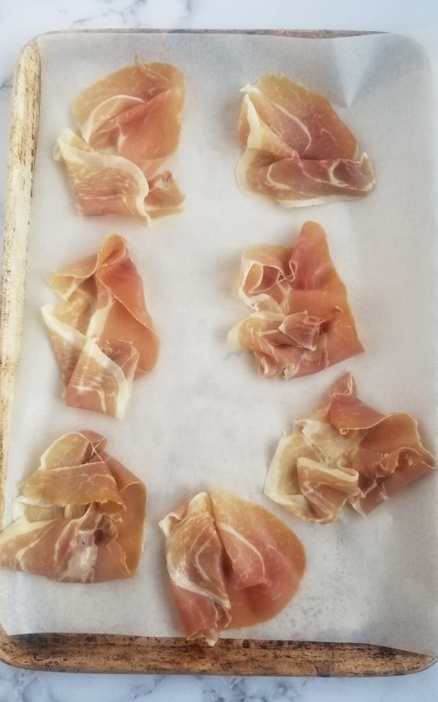 7 slices of prosciutto on a parchment lined baking sheet