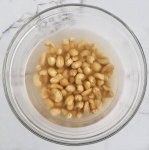 clear bowl with cashews soaking in water