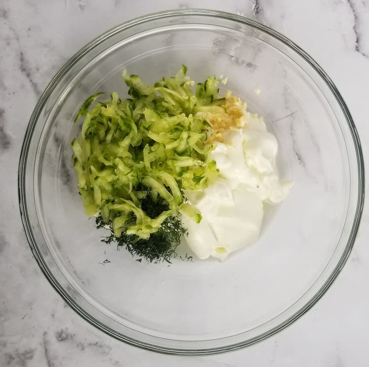 bowl of fresh dill, greek yogurt, minced garlic, shredded cucumber