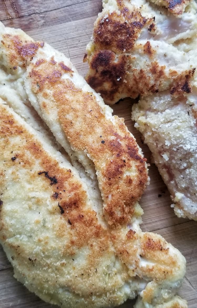 close up of two lightly fried breaded chicken breasts
