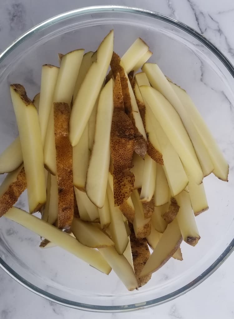 bowl with fresh cut french fries that have been soaked in water