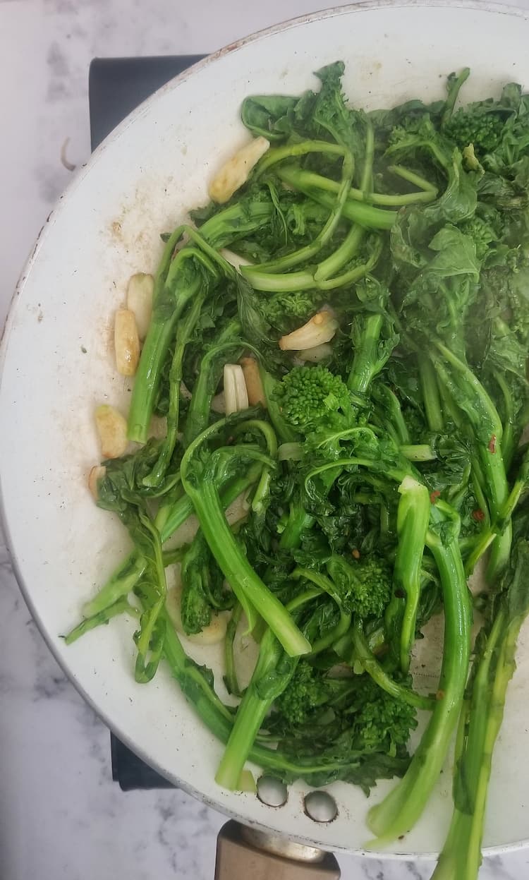 skillet with steamed garlic and rapini