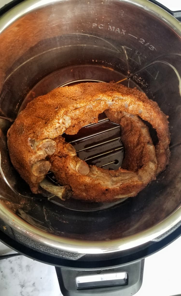 instant pot with two rack of ribs in a coil