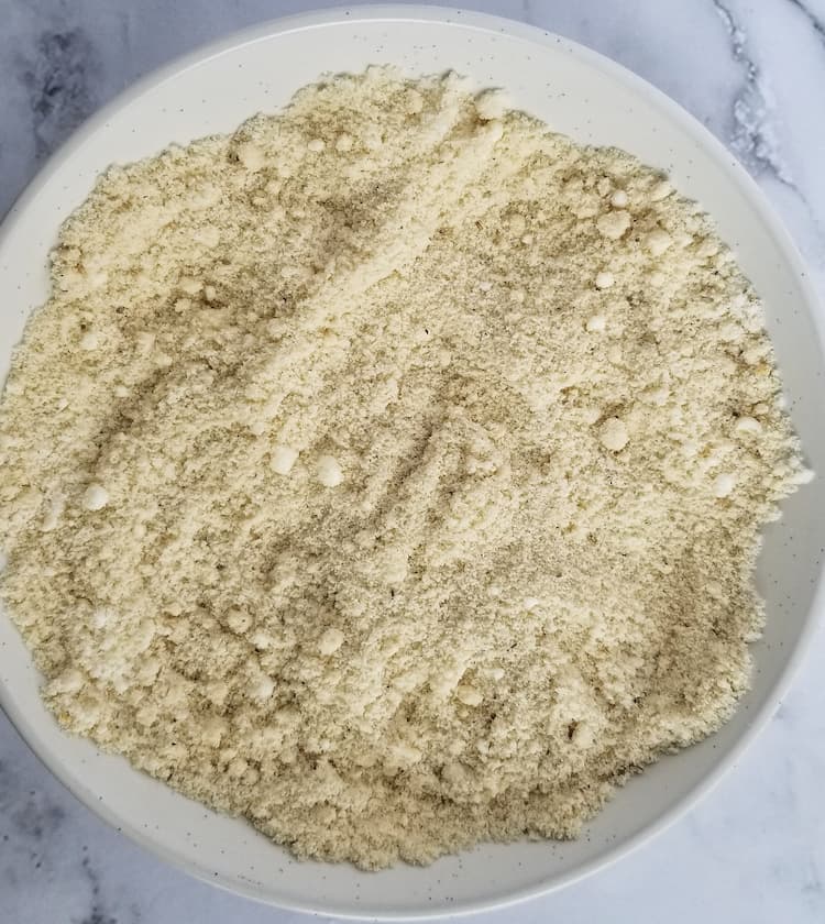 a white bowl of flour, spices and parmesan cheese