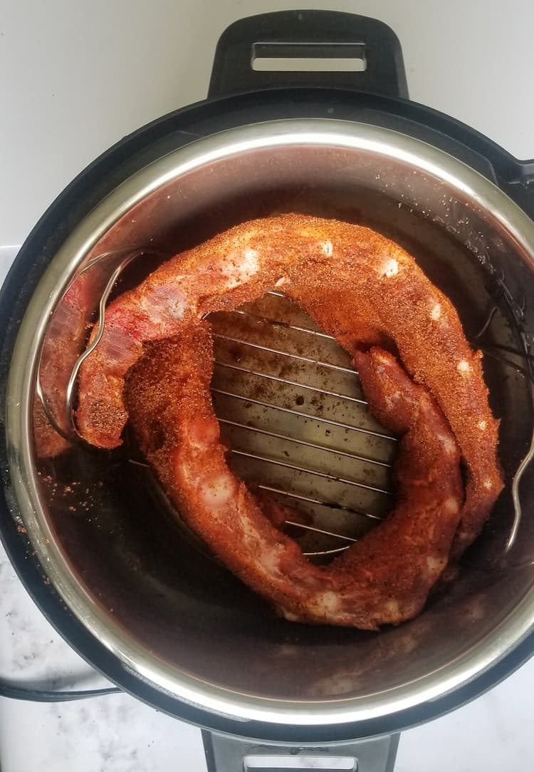 instant pot with two coiled racks of ribs