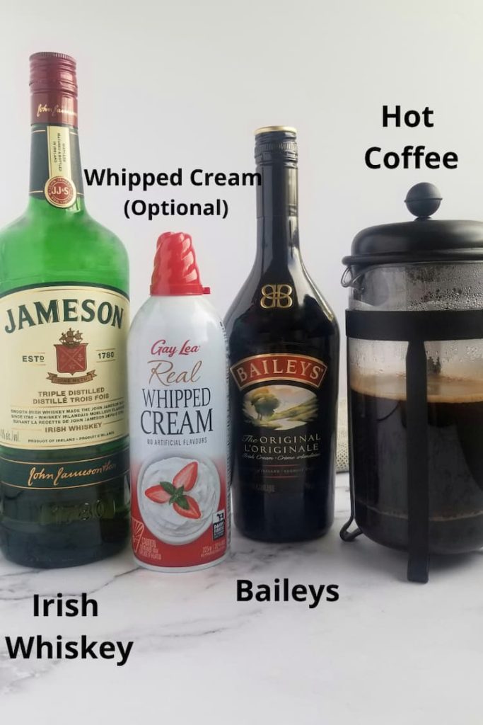 ingredients for irish coffee with baileys - bottle of jameson, can of whipped cream, bottle of baileys, hot coffee in a coffee press