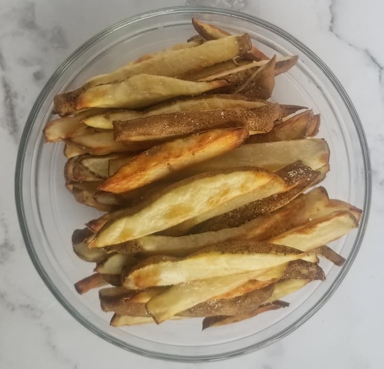 bowl of cooked air fryer fries topped with salt