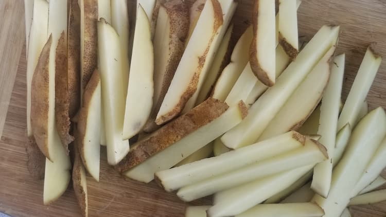 cutting board with fresh cut french fries