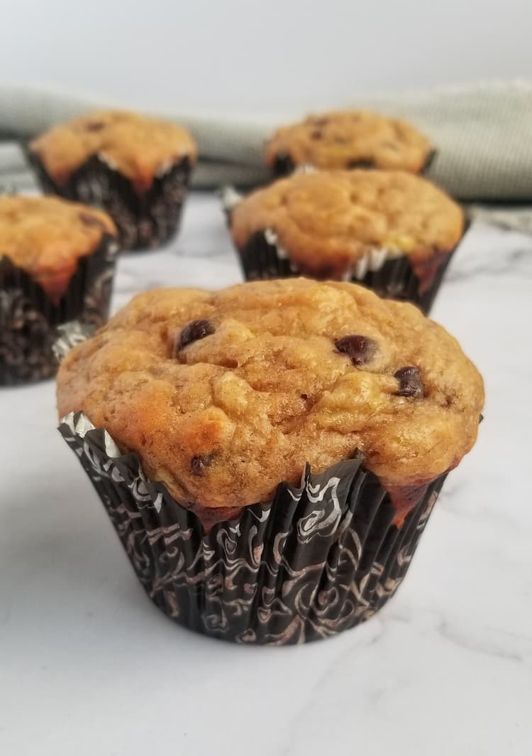 5 freshly baked muffins in muffin liners with chocolate chips