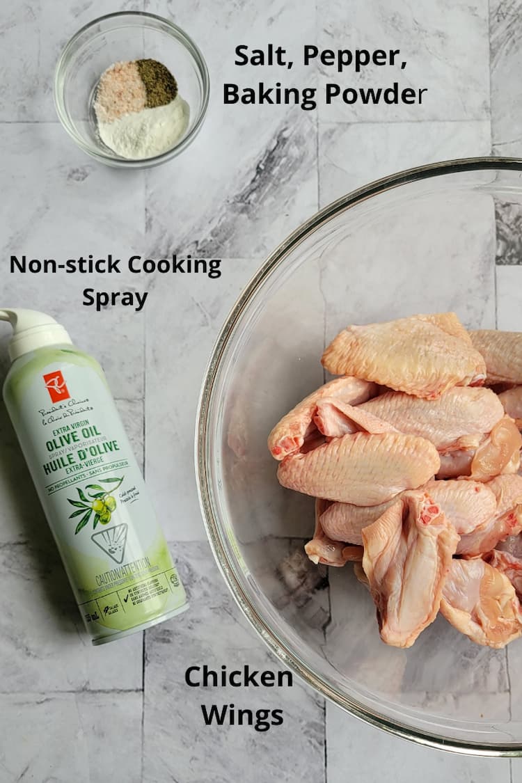 ingredients for air fried chicken wings recipe - bowl of raw chicken wings, salt, pepper, baking powder, non-stick cooking spray