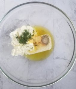 bowl with cream cheese, sour cream, minced garlic, pickle juice, herbs and spices