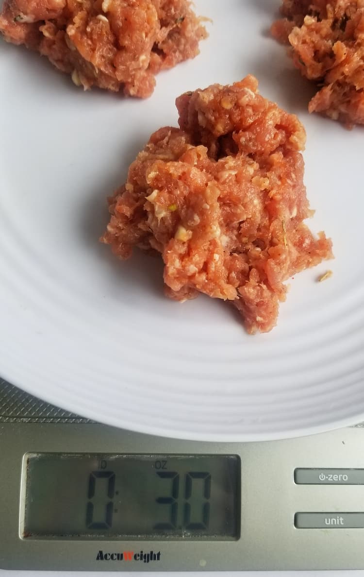 plate of ground meat in balls on a scale revealing a number of 3.0 oz
