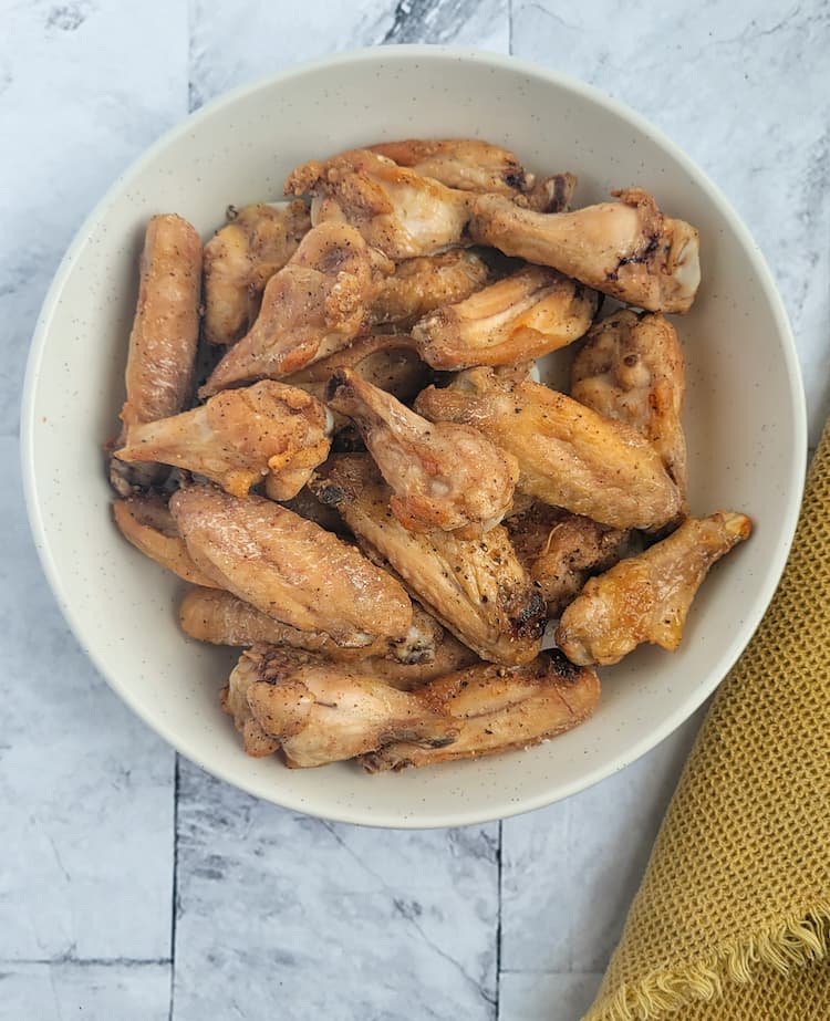 bowl of crispy air fried chicken wings seasoned with salt and pepper