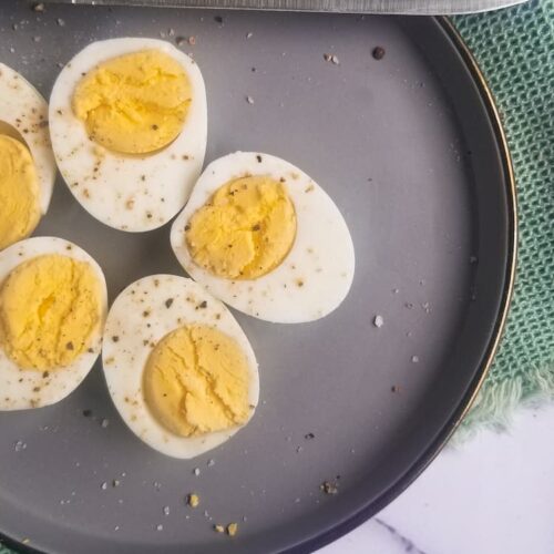plate of halved hard boiled eggs next to a knife