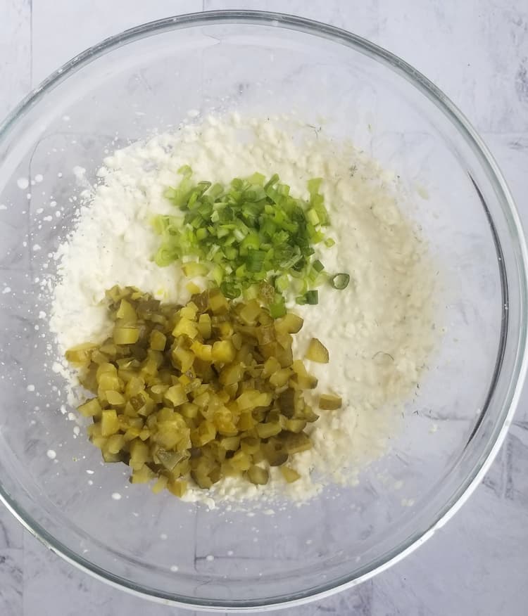 bowl of chopped pickles, green onions and white stuff