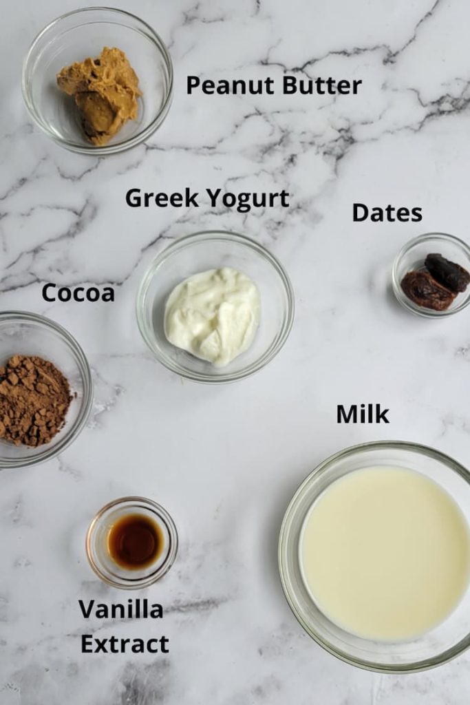 ingredients for chocolate peanut butter smoothie - cocoa, peanut butter, milk, greek yogurt, vanilla extract, dates