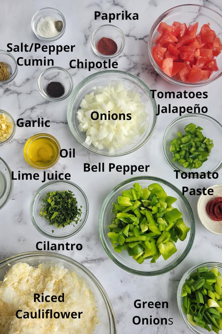ingredients for cauliflower rice mexican - riced cauliflower, tomatoes, green onions, cilantro, green pepper, tomato paste, jalapenos, paprika, salt/pepper, chipotle powder, cumin, onions, garlic, oil, lime juice