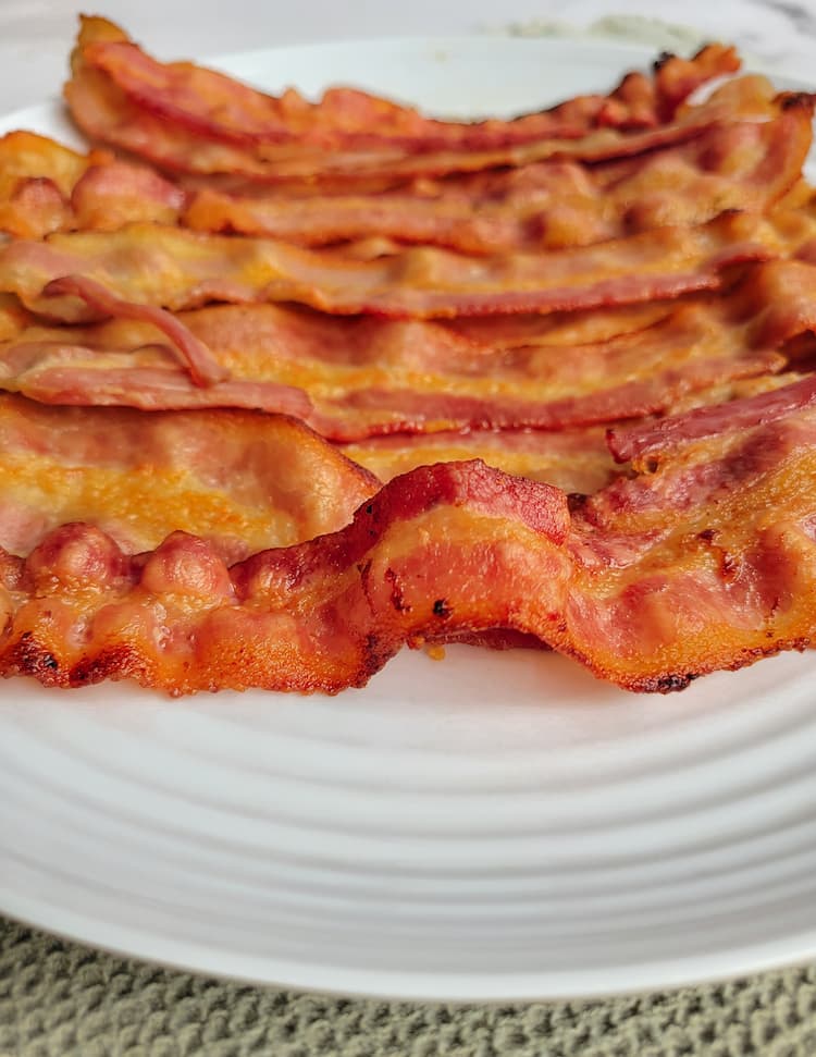 side view of cooked bacon on a plate