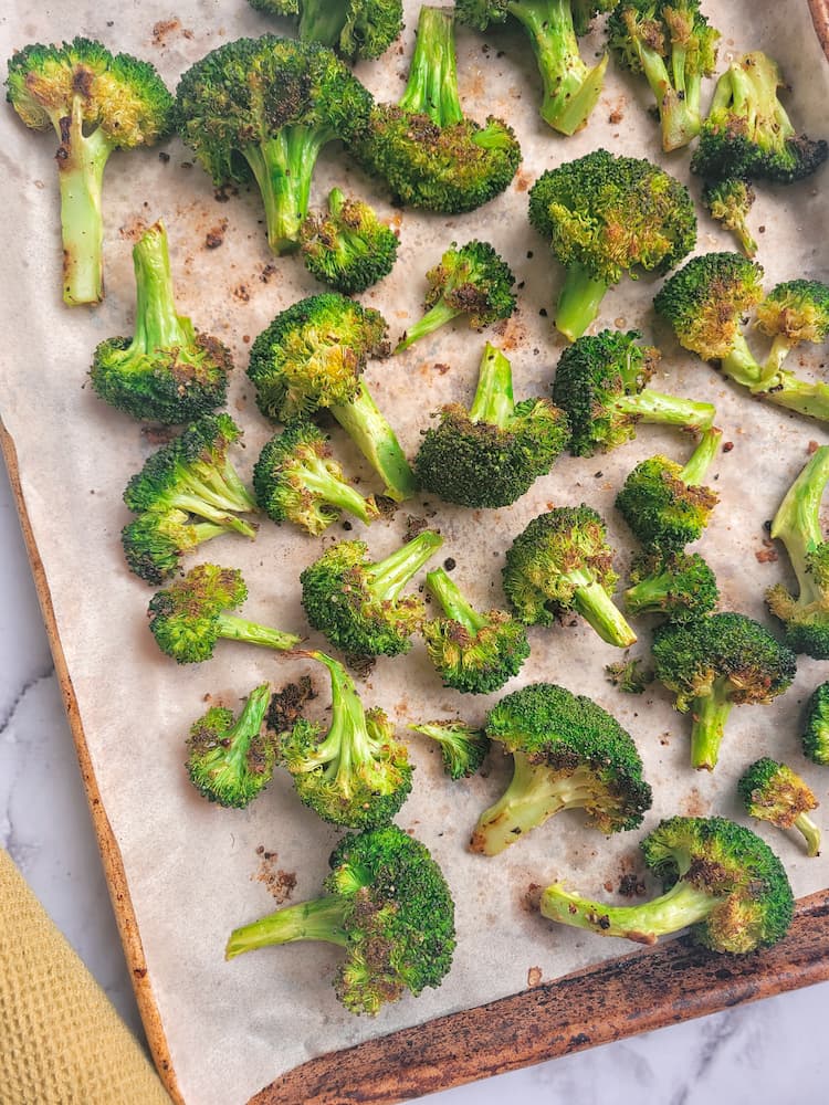 parchment lined sheet pan with oven roasted broccoli florets