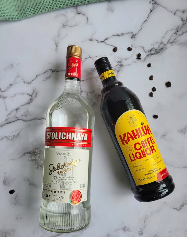 bottle of stolichnaya vodka and kahlua next to some scattered coffee beans
