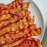 pile of cooked strips of bacon on a plate