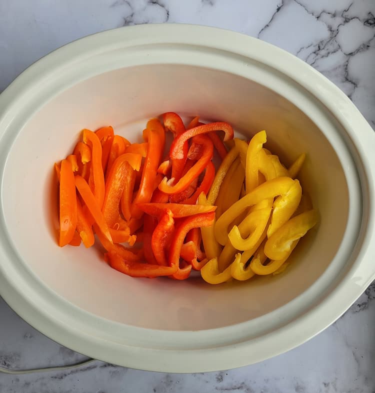 crockpot of sliced orange, red and yellow peppers