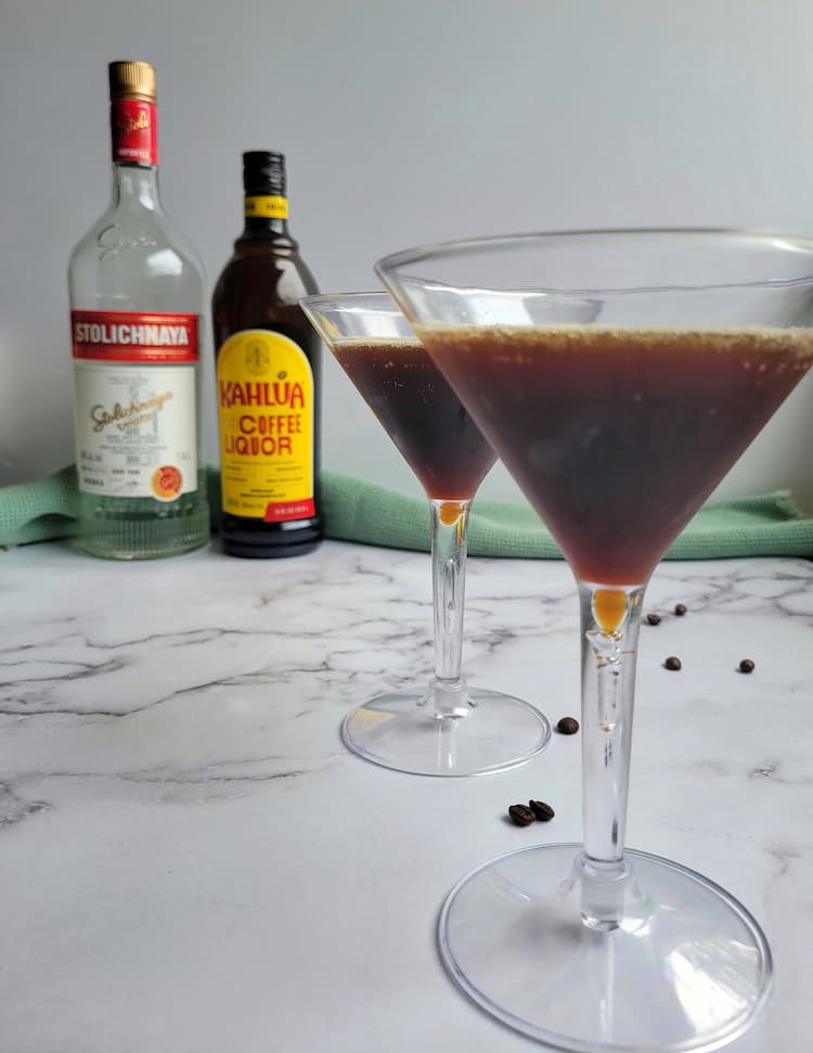 two espresso martinis in front of a bottle of vodka and kahlua