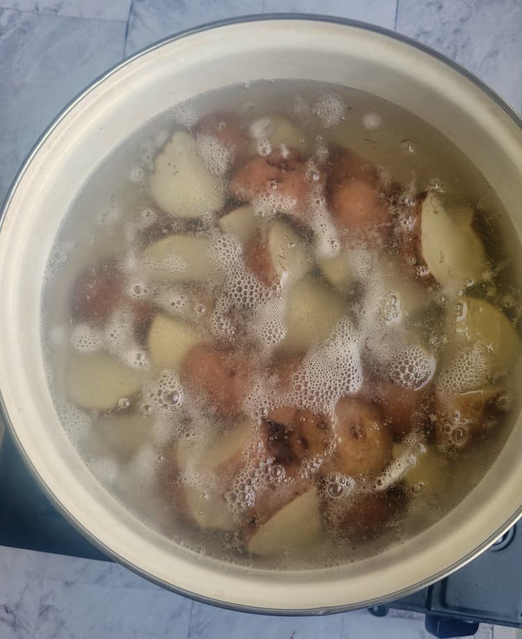 pot of boiling halved red skinned potatoes