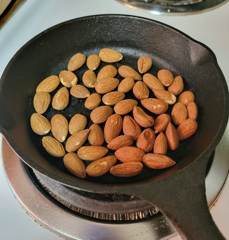 small cast iron skillet with whole almond on a stove top