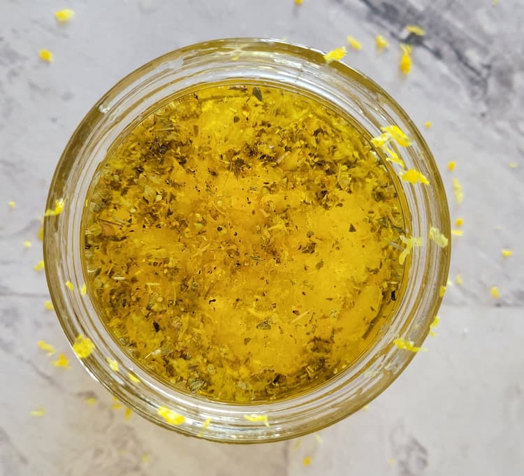 small glass bowl with olive oil, spices and lemon zest