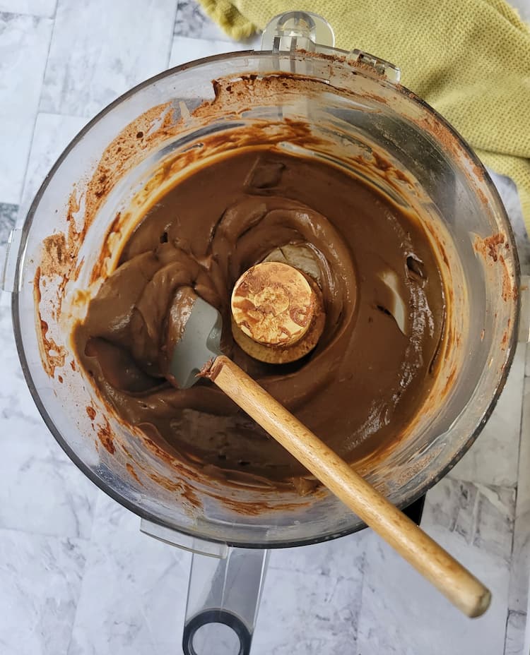 food processor base with smooth chocolate and a small rubber spatula