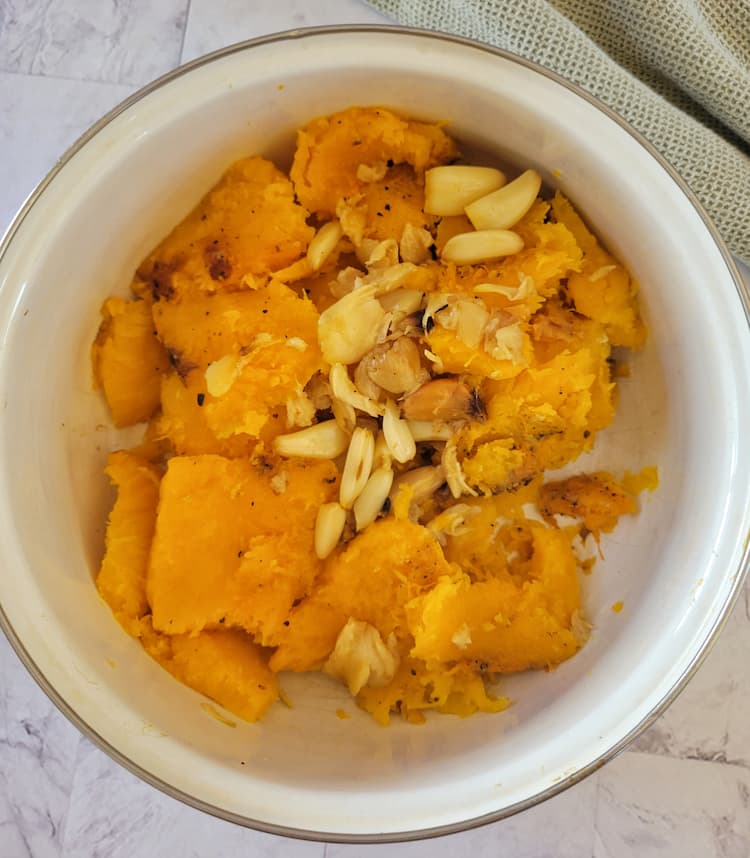 pot with roasted butternut squash chunks and roasted garlic cloves