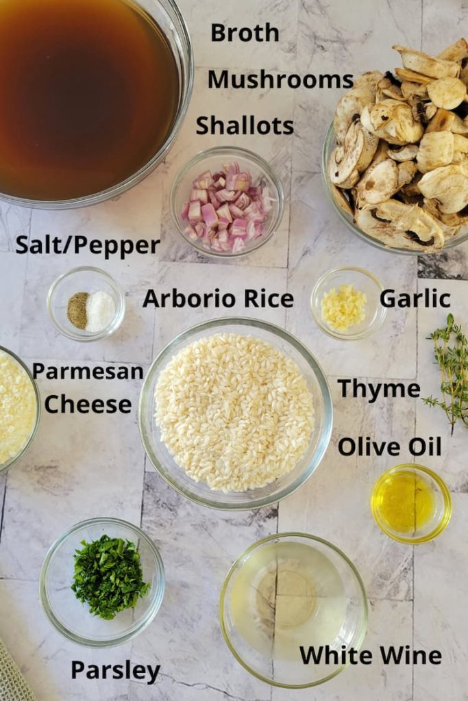 ingredients for recipe for mushroom risotto - mushrooms, arborio rice, shallots, garlic, thyme, parsley, salt and pepper, broth, parmesan cheese, olive oil, white wine