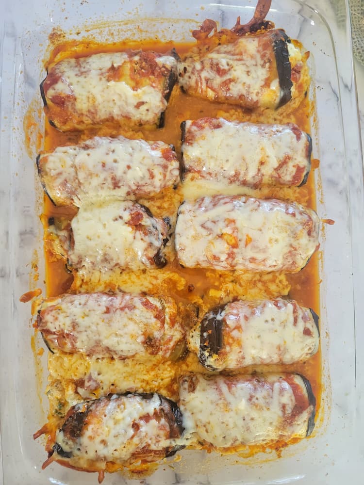 glass baking dish with eggplant rollatini with tomato sauce and mozzarella cheese