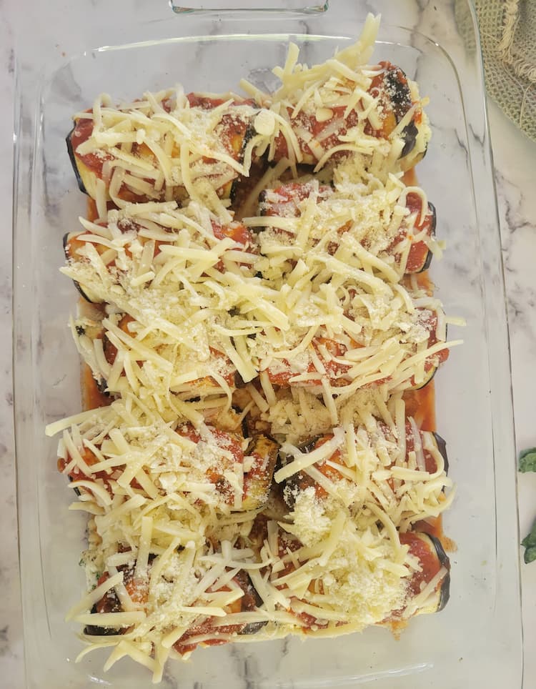 glass baking dish with eggplant rollatini with tomato sauce and mozzarella cheese (uncooked)