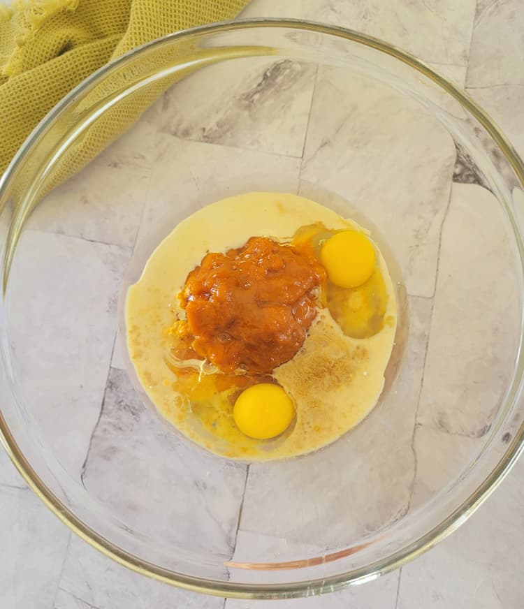 bowl with 2 eggs, milk, pumpkin puree and other wet baking ingredients