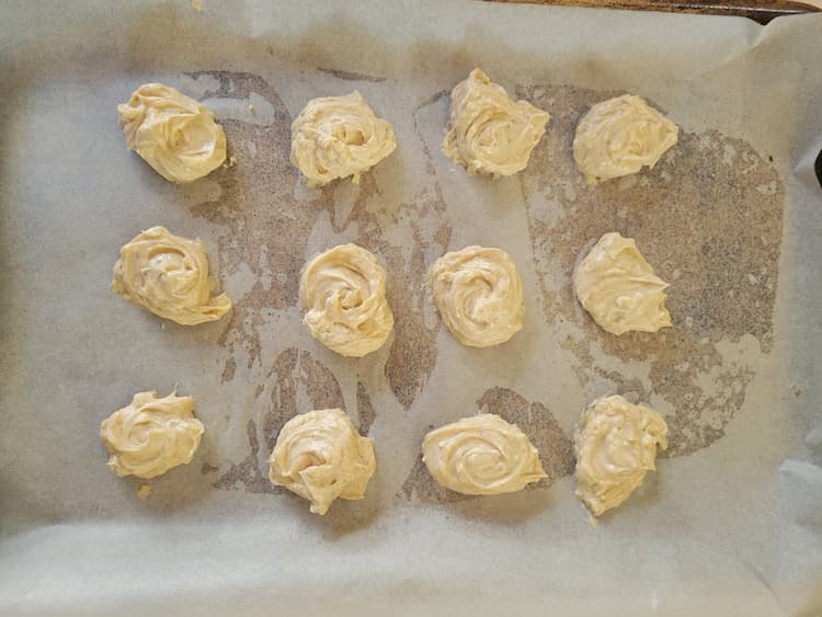 parchment lined baking sheet with frozen balls of cream cheese