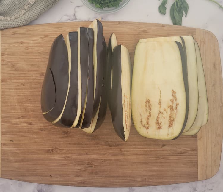 cutting board with two large eggplants on a cutting board