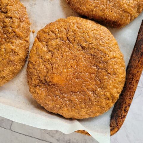 cookies with pumpkin spice freshly baked on a parchment lined baking sheet